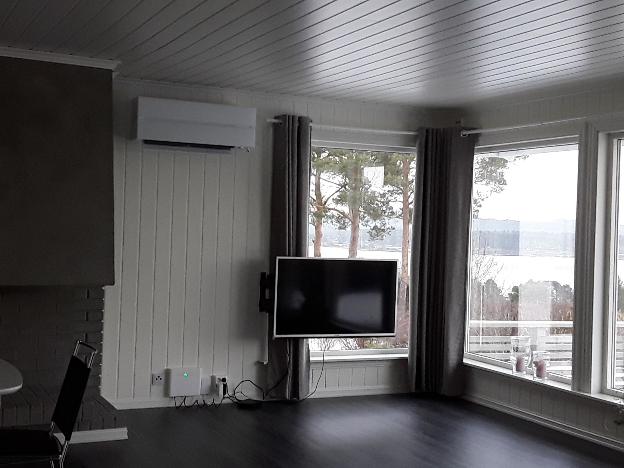 Interiør med varmepumpe installert i en stue med mange store vindu